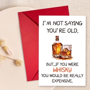 Vista de detalle de tarjeta de cumpleaños whisky con sobre sobre fondo de lino blanco