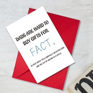 Close-up of white greeting card with blue text and a vibrant red envelope on marble background