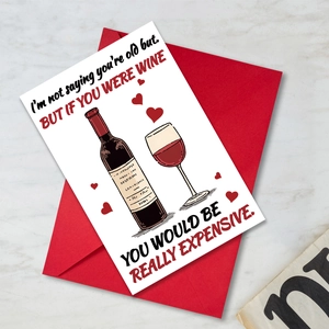 Detalle de tarjeta humorística de San Valentín con ilustración de vino y sobre rojo