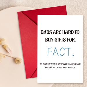 Flat lay of Father's Day greeting card with humor quote and red envelope on linen