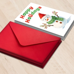 Detalle de tarjetas navideñas con muñecos de nieve en acuarela y sobres rojos