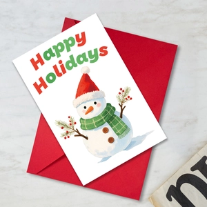 Detalle de tarjeta de Navidad con muñeco de nieve, texto festivo y un sobre rojo
