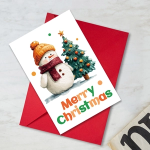 Watercolor snowman Christmas card with red envelope on a clean marble table
