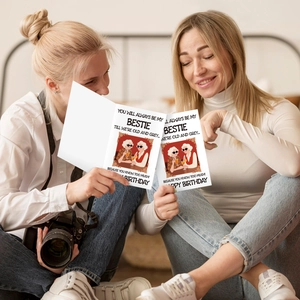 Lifestyle shot of two friends sharing a humorous birthday card with cartoon illustration