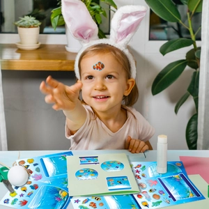Nahaufnahme eines Kindes, das mit Unterwasserwelt-Stickern und Korallen-Meeresmotiven spielt