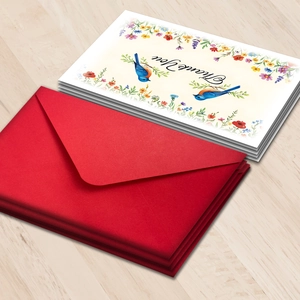 Macro view of watercolor floral thank you card with a premium textured red envelope