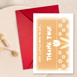 Close-up of floral thank you card with white daisy pattern and matching red envelope