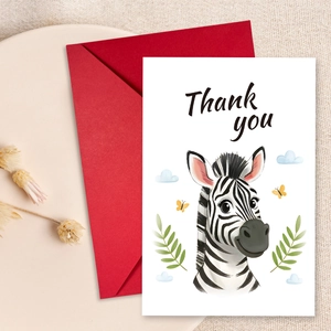Detail view of cartoon zebra thank you card with a red envelope on a beige tray