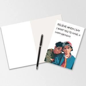 Close-up of a large folded birthday card with anime illustration and a black pen