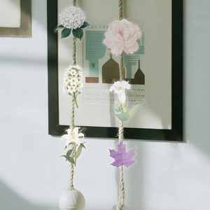 Detail of white flower and purple leaf PET stickers hanging on creative twine display