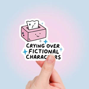 Detail van schattige sticker met Crying Over Fictional Characters tekst op zachte achtergrond