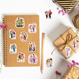 Macro view of waterproof cartoon couple stickers on craft notebook and gift packaging
