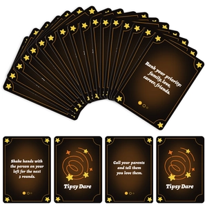 Detail view of Tipsy Dare drinking game cards with golden star patterns on black cardstock