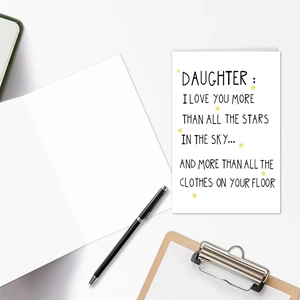 Close-up of humor text greeting card for daughter with a star design and stationery items