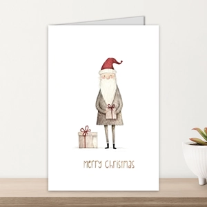 Vintage Christmas card with hand-painted Santa Claus and gift box on a white wooden surface