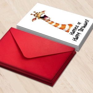 Funny giraffe birthday card set with red envelopes on a wooden background
