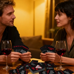 Primer plano de cartas de juego para parejas con copas de vino tinto y luz cálida