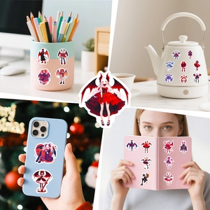 Lolita demon girl stickers decorating a notebook, phone case, and various desk items