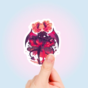 Detail shot of a red-haired devil girl sticker with bat wings in gothic Lolita style