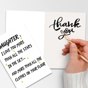 Detailed view of large humorous daughter greeting card with yellow stars and wooden pen