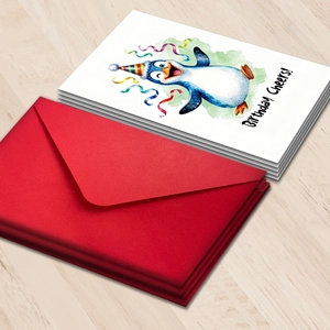 Cartoon penguin birthday cards set with red envelopes on a light wood background