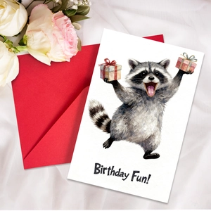 Macro detail of watercolor raccoon birthday card with a red envelope on white silk