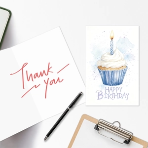 Close-up of watercolor birthday card with cupcake and Thank You note set on clipboard
