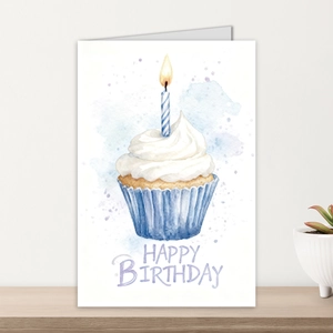 Close-up of watercolor birthday card with cupcake illustration on a wooden desk