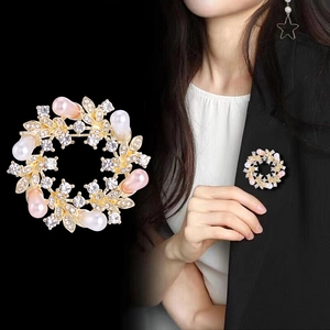 Detailed view of floral pearl brooch with gold base on suit lapel for elegant styling