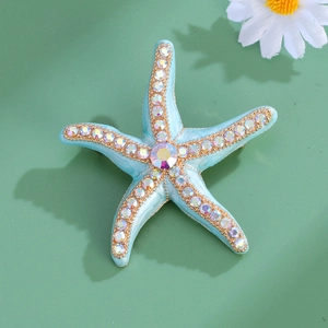 Elegant gold-tone starfish brooch with light blue enamel and sparkling AB rhinestones