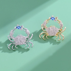 Elegant crab brooch with diamonds in gold and silver finishes on a mint green background