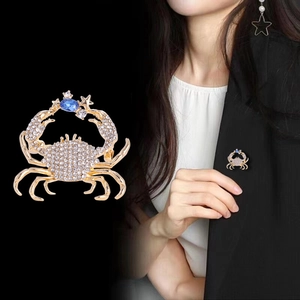 Detailed view of luxury crab brooch with sparkling rhinestones and blue gemstone