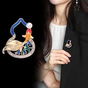 Detail of koi fish gourd brooch with enamel finish and pearl on black blazer lapel