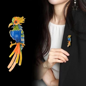 Enamel parrot brooch in vibrant colors on gold metal pinned to a black blazer