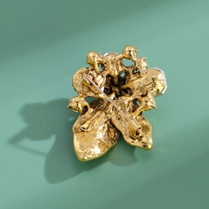 Vintage Blumenbrosche in Gold mit Kristallen und strukturierter Metalloberfläche