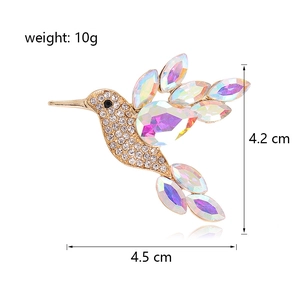 Exquise broche colibri dorée avec cristaux colorés et strass brillants pour vêtements