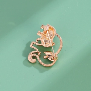Back view of gold elephant brooch showing secure pin clasp and textured metal finish