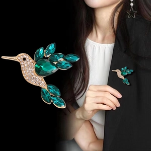 Broche colibri dorée avec strass blancs étincelants et cristaux vert foncé