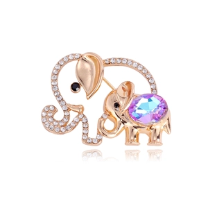 Golden elephant brooch with purple crystal and white diamonds on a white background
