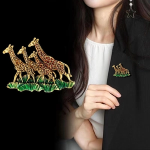 Detailed enamel giraffe brooch with four deer and greenery on a black suit lapel