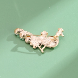 Vue arrière d'une broche paon dorée avec finition texturée et fermoir à épingle de sûreté