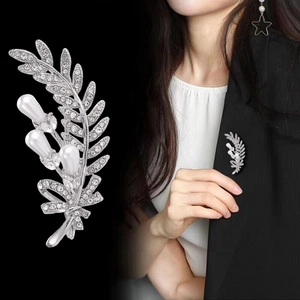Elegant wheat stalk leaf brooch with pavé rhinestones and white pearls on black backdrop