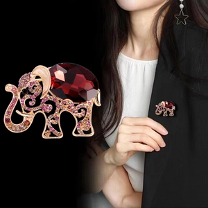 Sparkling crystal elephant brooch with large red gemstone set in a gold alloy base