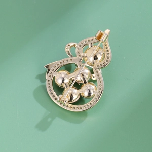 Élégante broche gourde en or avec pierres incrustées et épingle de sûreté au dos