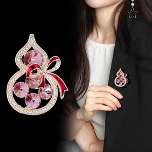 Vue macro d'une broche gourde à nœud papillon avec cristal rose et métal doré