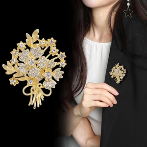 Broche bouquet de fleurs dorée élégante avec cristaux et nœud portée par un mannequin