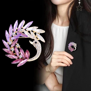 Detailed close-up of crystal swan brooch with purple gradient and sparkling rhinestones