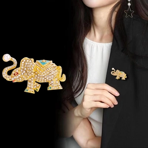 Exquisite gold elephant brooch with white rhinestones, blue enamel, and a faux pearl accent