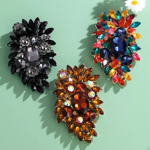 Luxury rhinestone glass brooches in three vintage colors on a light green background