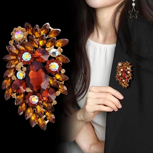 Vintage gold brooch with amber crystals shown on black blazer with a macro detail view